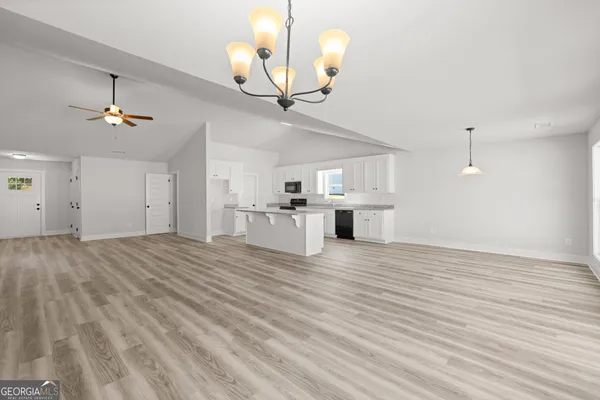 a view of a kitchen with a sink dishwasher a kitchen view and a chandelier