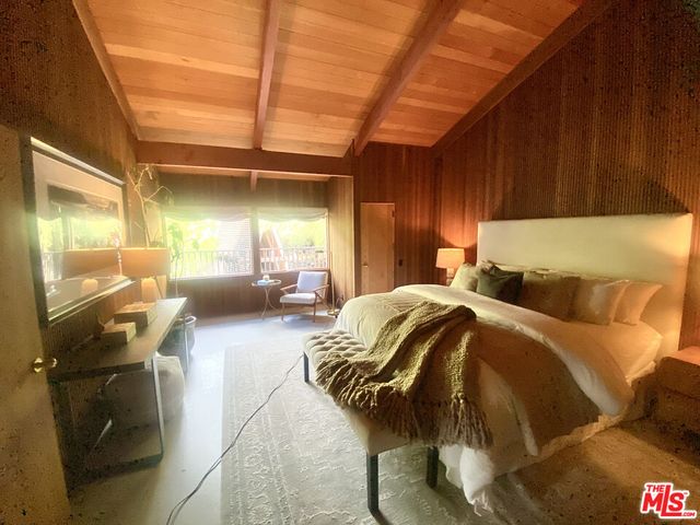 a bed sitting in a bedroom next to a window