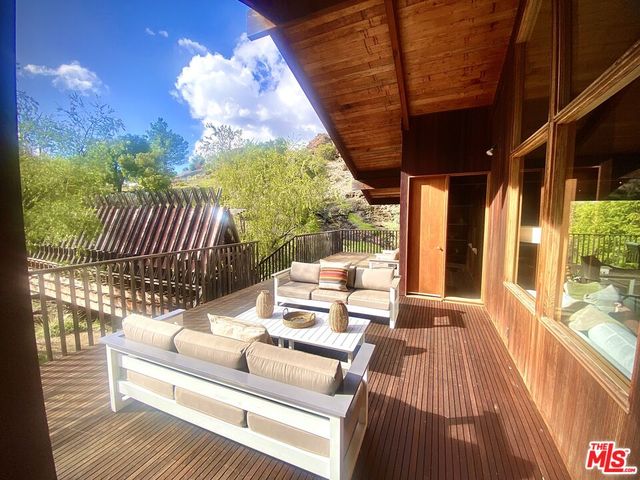 a view of a patio with couches table and chairs and potted plants