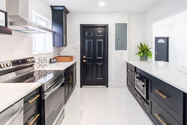 a large kitchen with stainless steel appliances granite countertop a sink stove and refrigerator