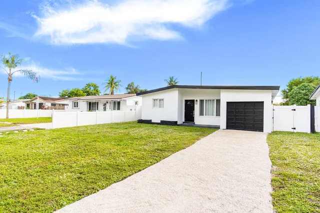 a front view of a house with a yard and lake view