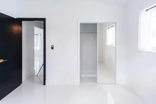 a view of a white house with a big yard and large trees