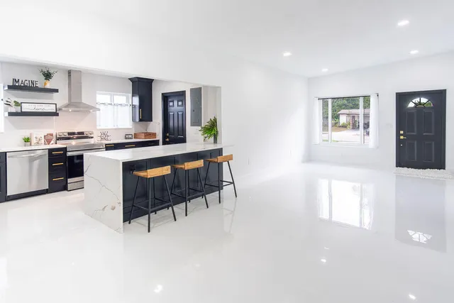 a kitchen with stainless steel appliances granite countertop a stove a sink dishwasher and a refrigerator with wooden floor