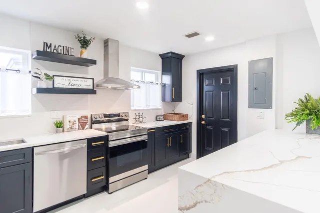 a kitchen with stainless steel appliances a stove a sink and a counter space
