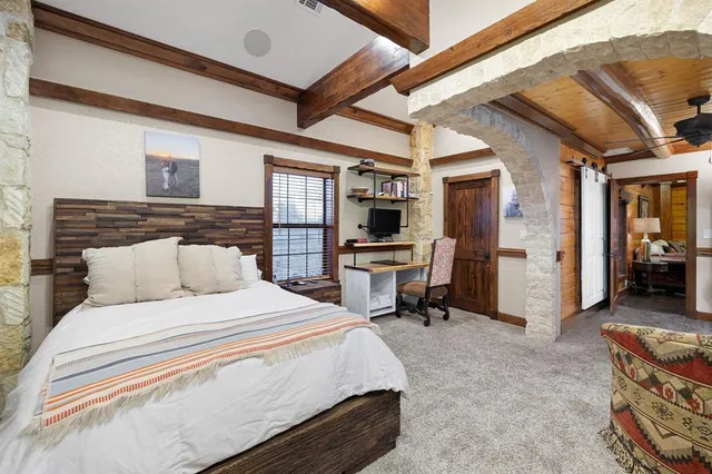 a spacious bedroom with a bed a dresser and a bookshelf