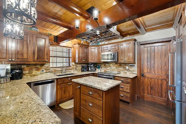 a kitchen with a sink a counter and chairs