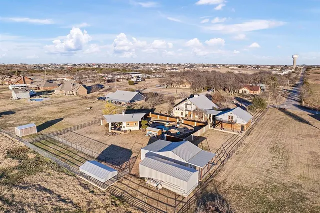 an aerial view of ocean and residential houses with outdoor space