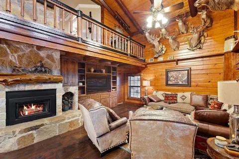 a living room with furniture a fireplace and a floor to ceiling window