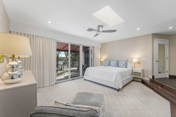 a spacious bedroom with a large bed and a chandelier