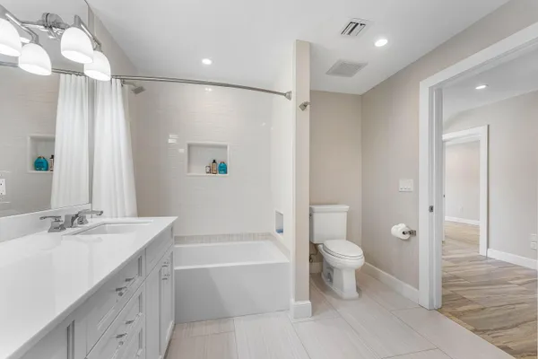 a bathroom with a sink a toilet a window and vanity