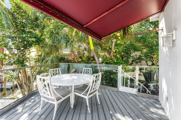 a view of a chairs and table in the balcony