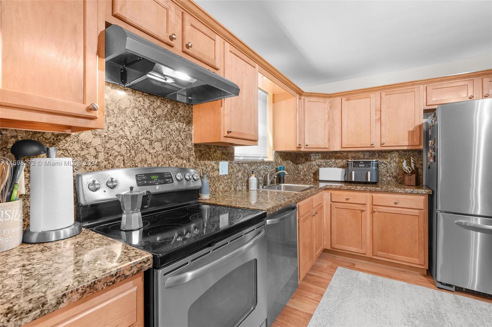 605 Ives Dairy Road, Unit 3047 Miami, FL 33179 - Photo 13 of 39 a kitchen with stainless steel appliances granite countertop a stove a sink and a refrigerator