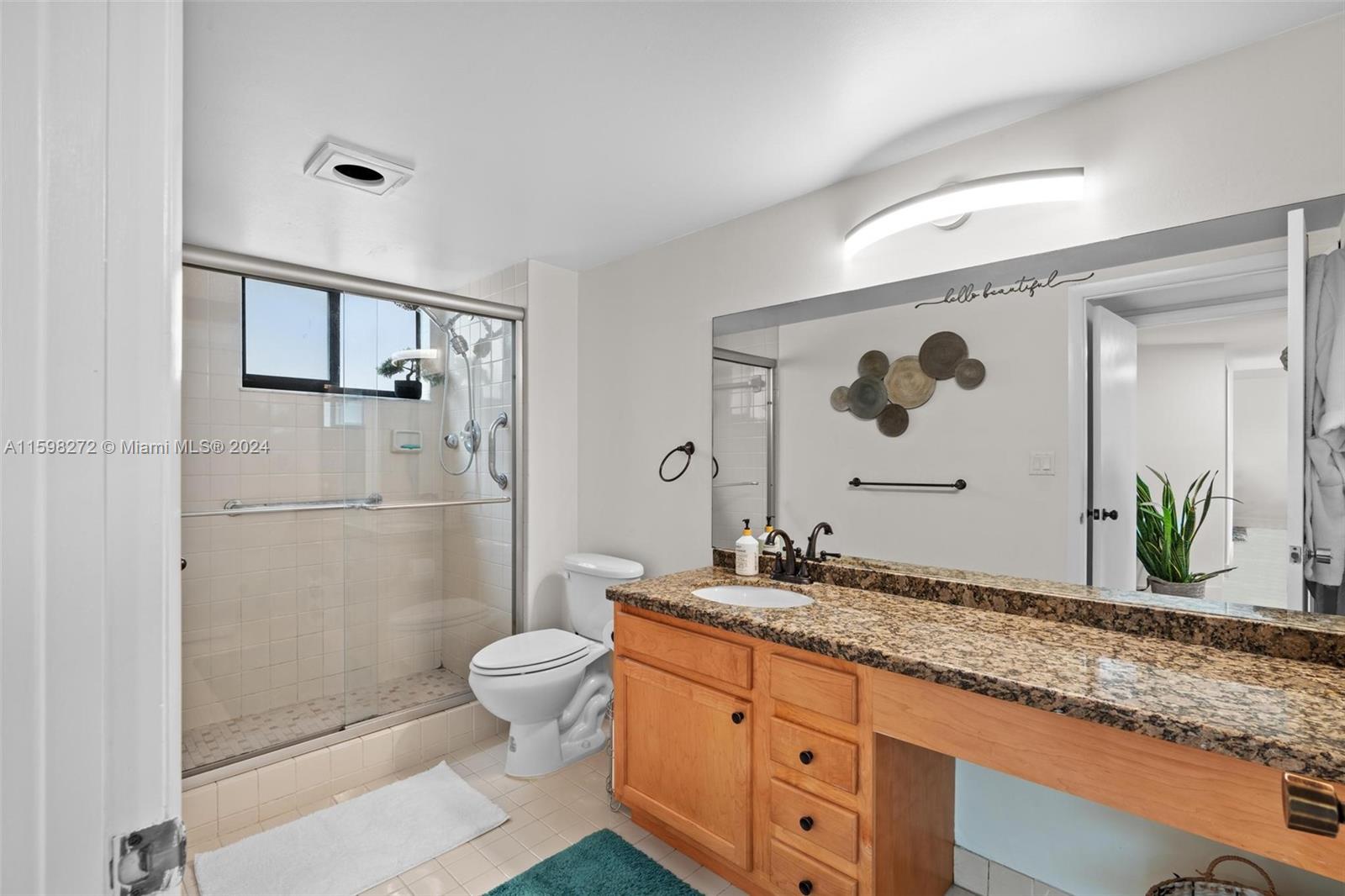 605 Ives Dairy Road, Unit 3047 Miami, FL 33179 - Photo 26 of 39 a bathroom with a granite countertop sink a toilet and shower