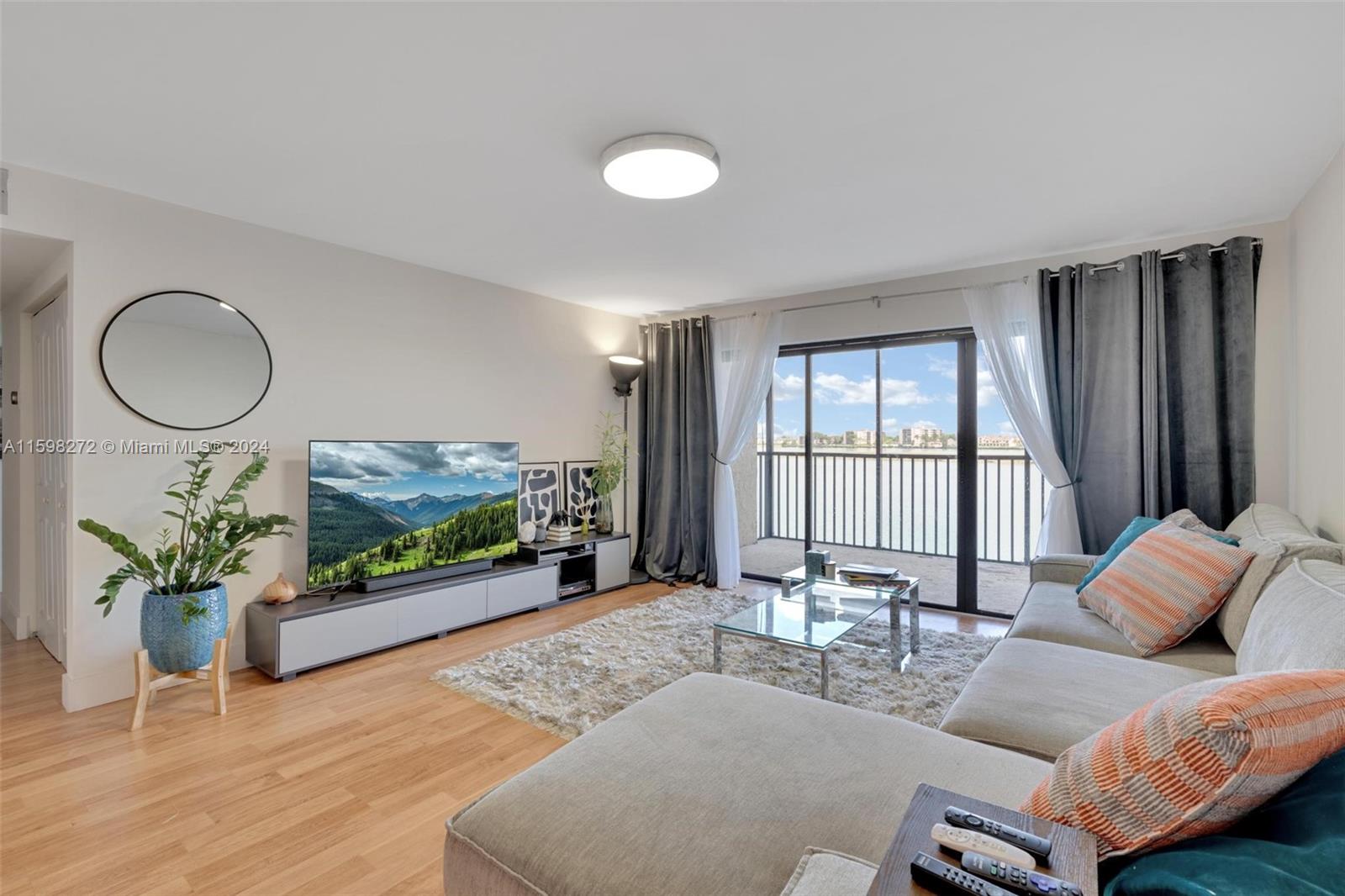 605 Ives Dairy Road, Unit 3047 Miami, FL 33179 - Photo 6 of 39 a living room with furniture and a flat screen tv