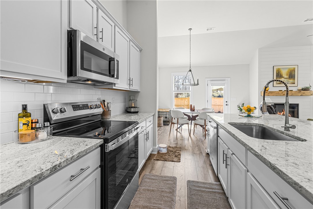 135 Bowers Estates Road Hartwell, GA 30643 - Photo 10 of 35 This bright kitchen features an island, ample counter space, and modern appliances perfect for daily living.