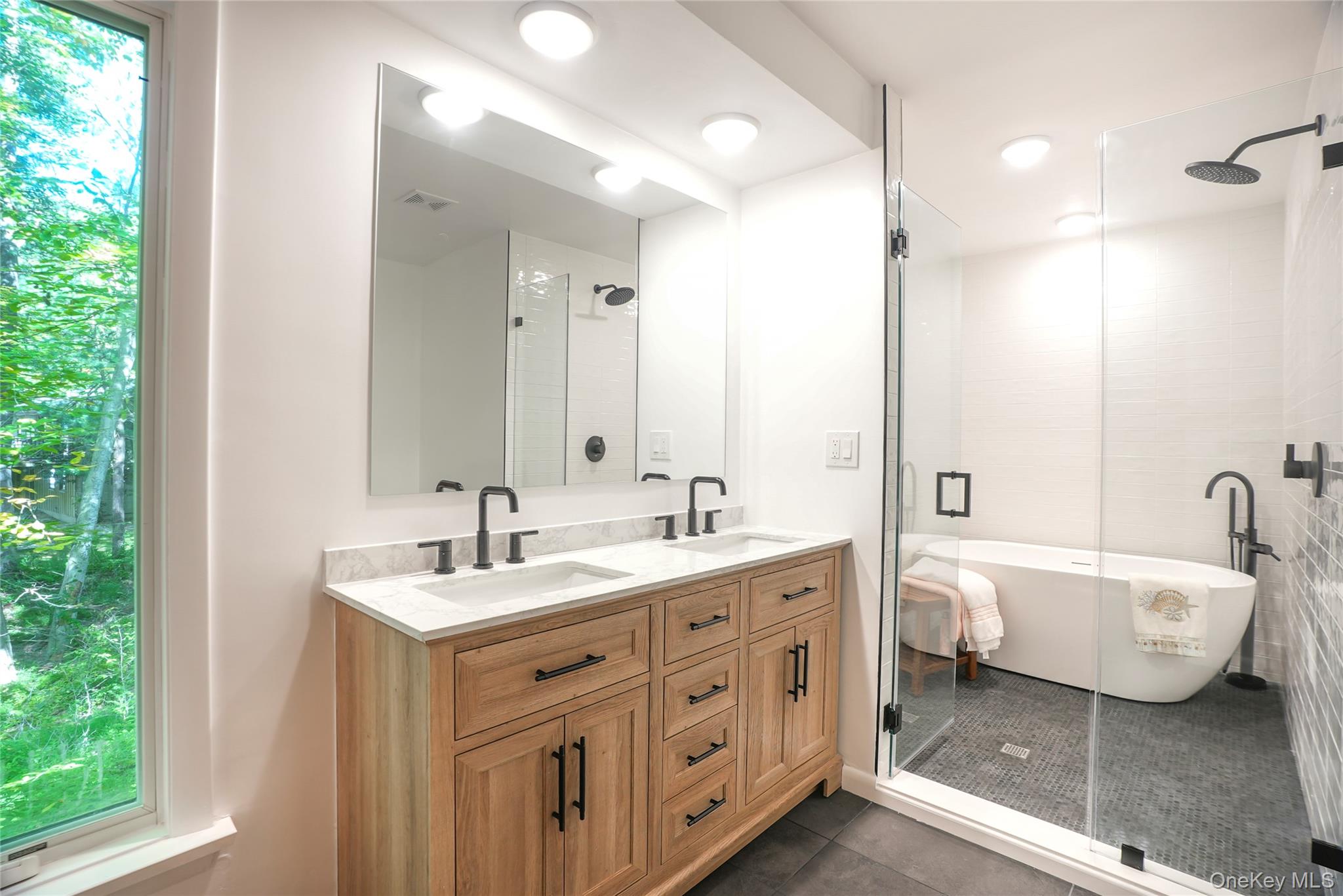 22 Peters Lane Pound Ridge, NY 10576 - Photo 20 of 43 Contemporary bathroom featuring a wood-finish double vanity with stone countertops and matte black fixtures