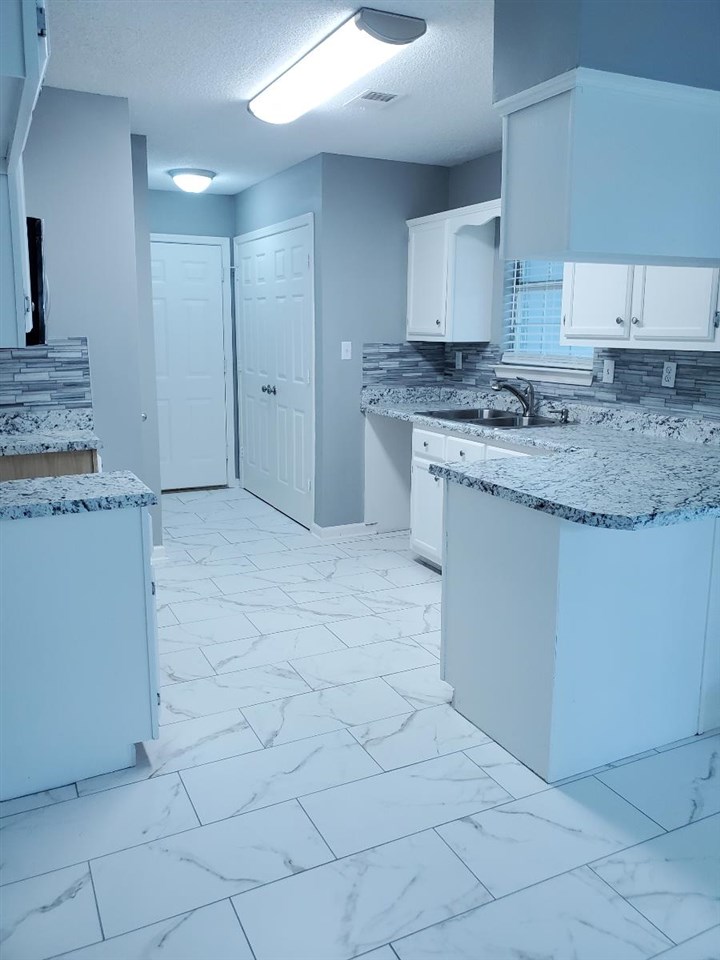 6748 State Line Road Memphis, TN 38141 - Photo 3 of 14 a kitchen with granite countertop white cabinets and a sink