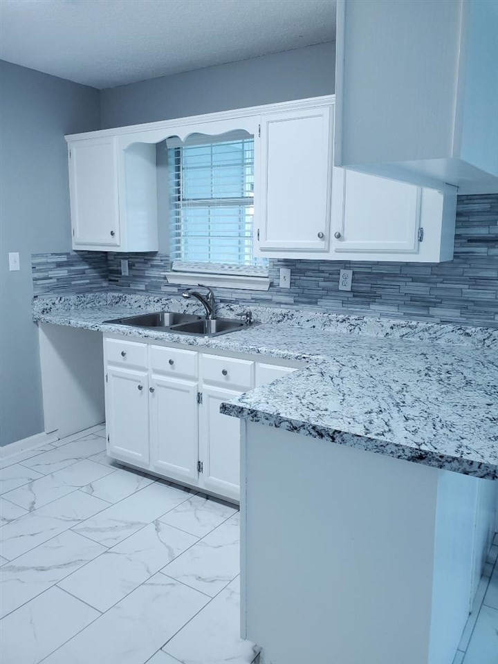 6748 State Line Road Memphis, TN 38141 - Photo 4 of 14 a kitchen with granite countertop a sink and cabinets