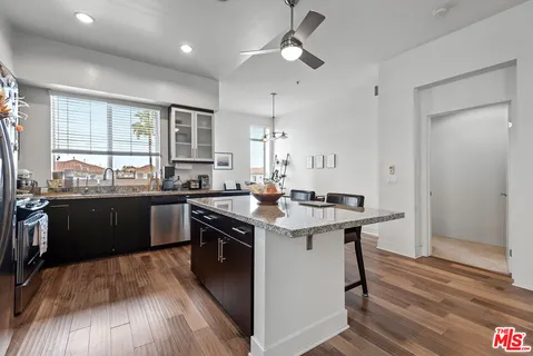 a kitchen with a counter space a sink appliances and wooden floor