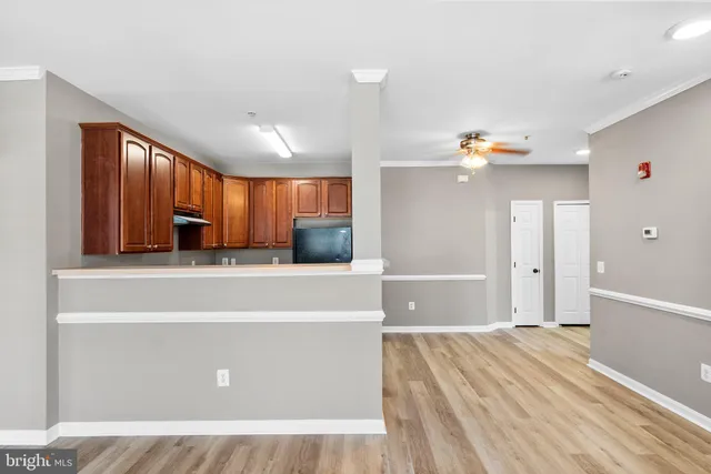 a view of a big room with wooden floor and windows