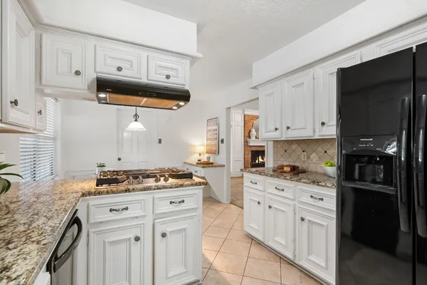 a kitchen with white cabinets and appliances