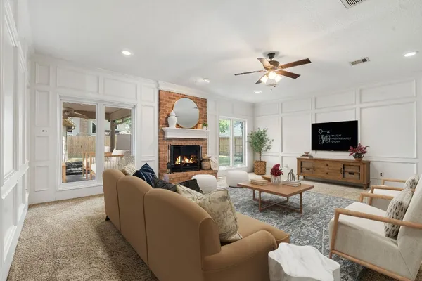 a living room with furniture a fireplace and a flat screen tv