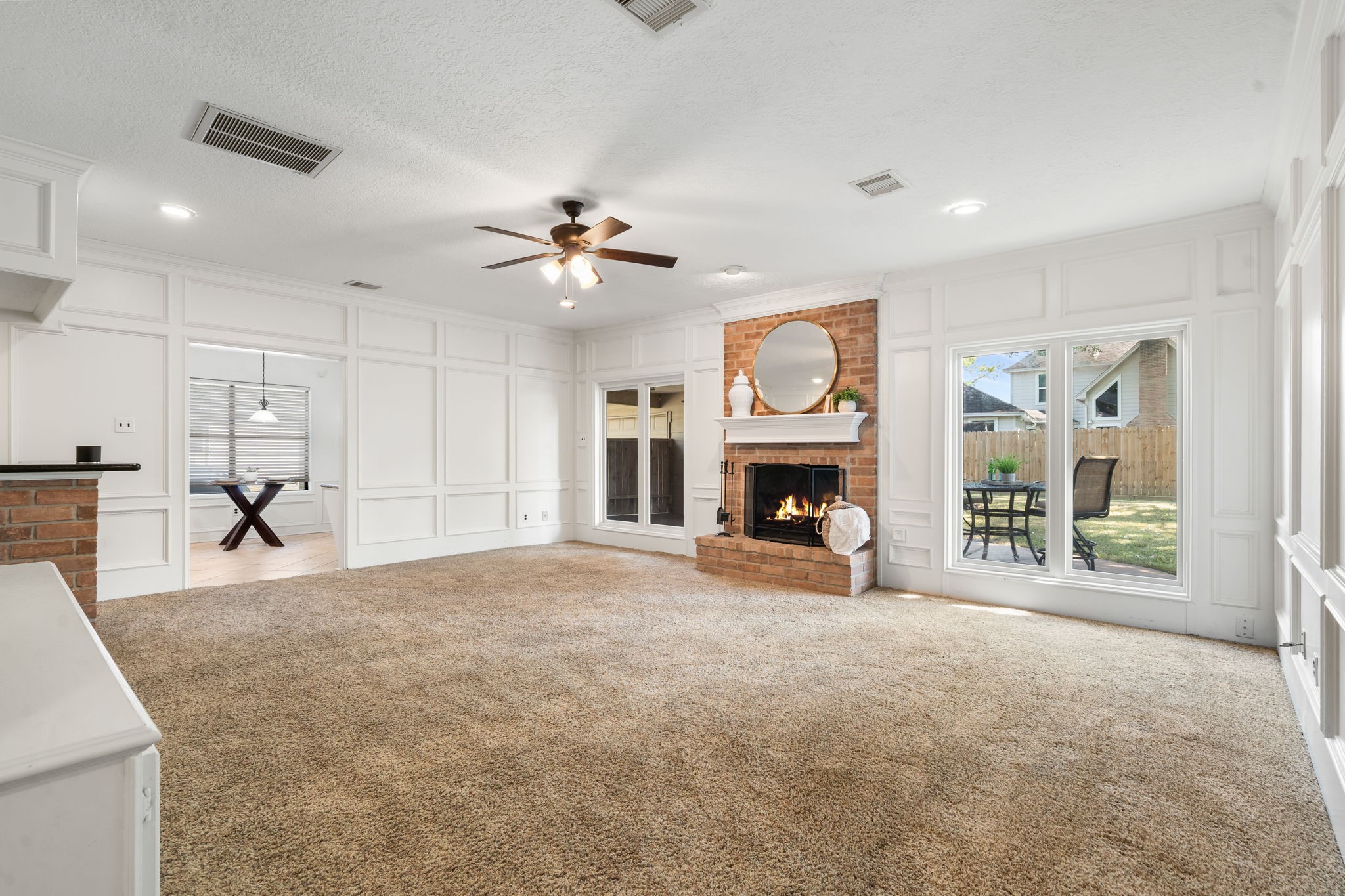 6403 Willow Pine Drive Spring, TX 77379 - Photo 6 of 40 This spacious living room is anchored by a cozy brick gaslog fireplace and features elegant custom wainscot paneling. Large windows and recessed lighting create a bright, inviting atmosphere with easy access to the breakfast room.