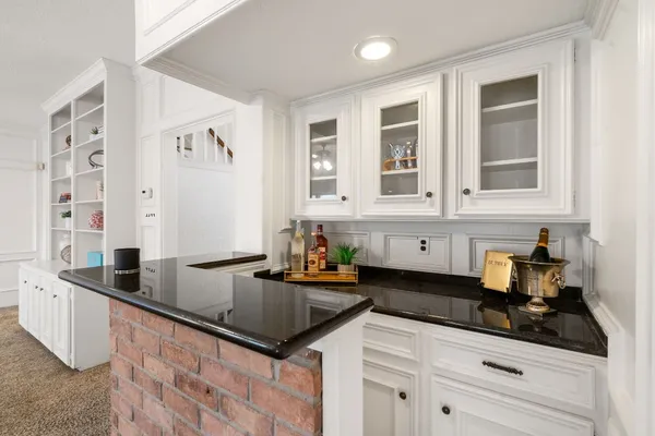 a kitchen with granite countertop a sink a stove and cabinets