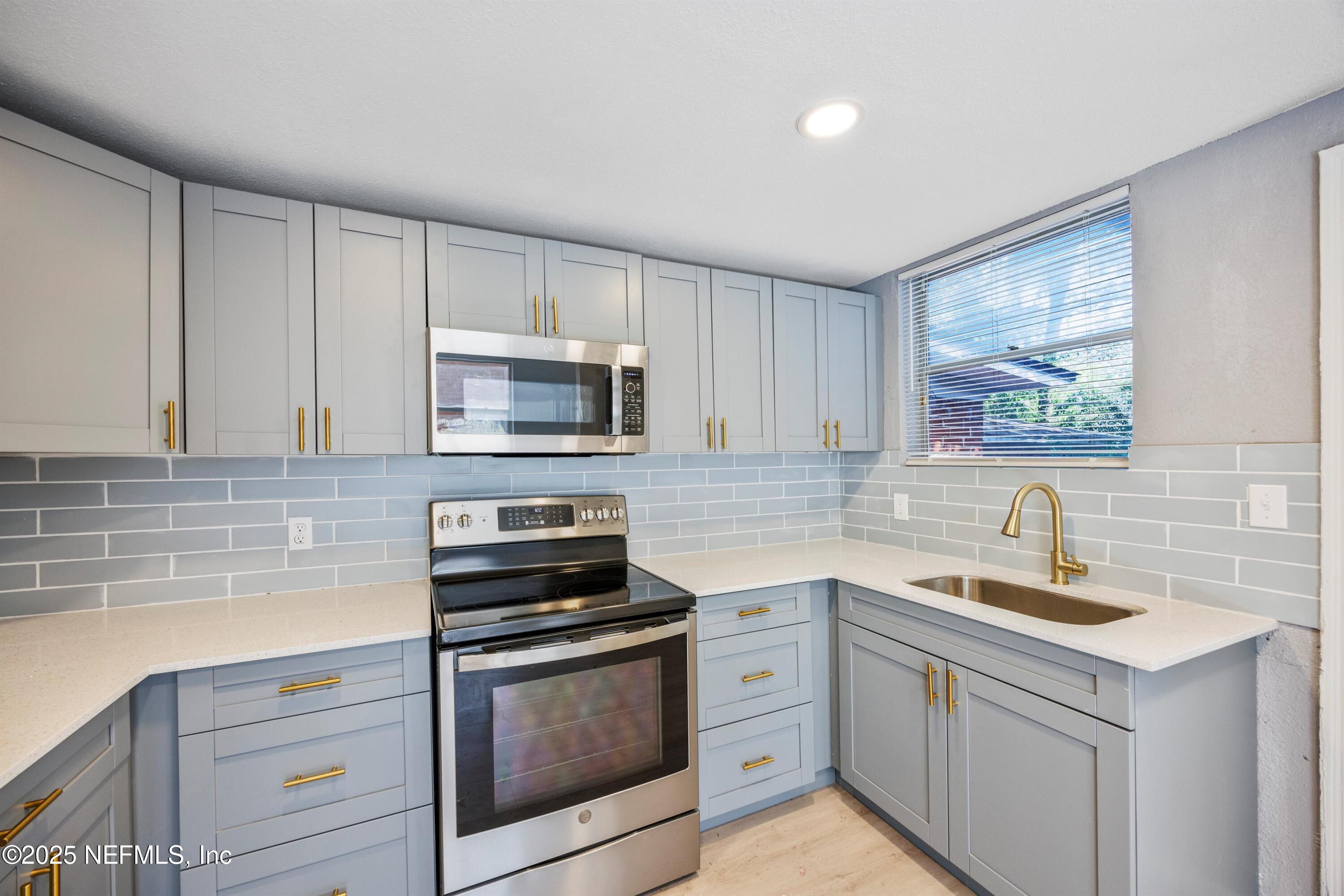 3150 Belden Circle Jacksonville, FL 32207 - Photo 49 of 69 a kitchen with white cabinets stainless steel appliances and sink