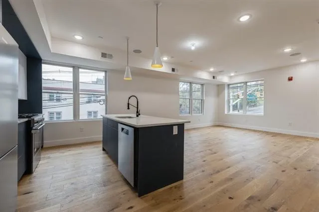 a kitchen with sink stove and refrigerator