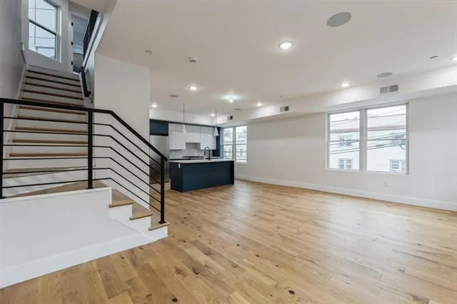 an entryway in a hall with a window and wooden floor