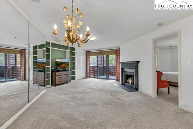 a view of an empty room with a fireplace and a chandelier