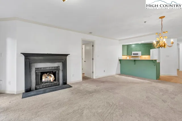 a view of an empty room with a fireplace and a window