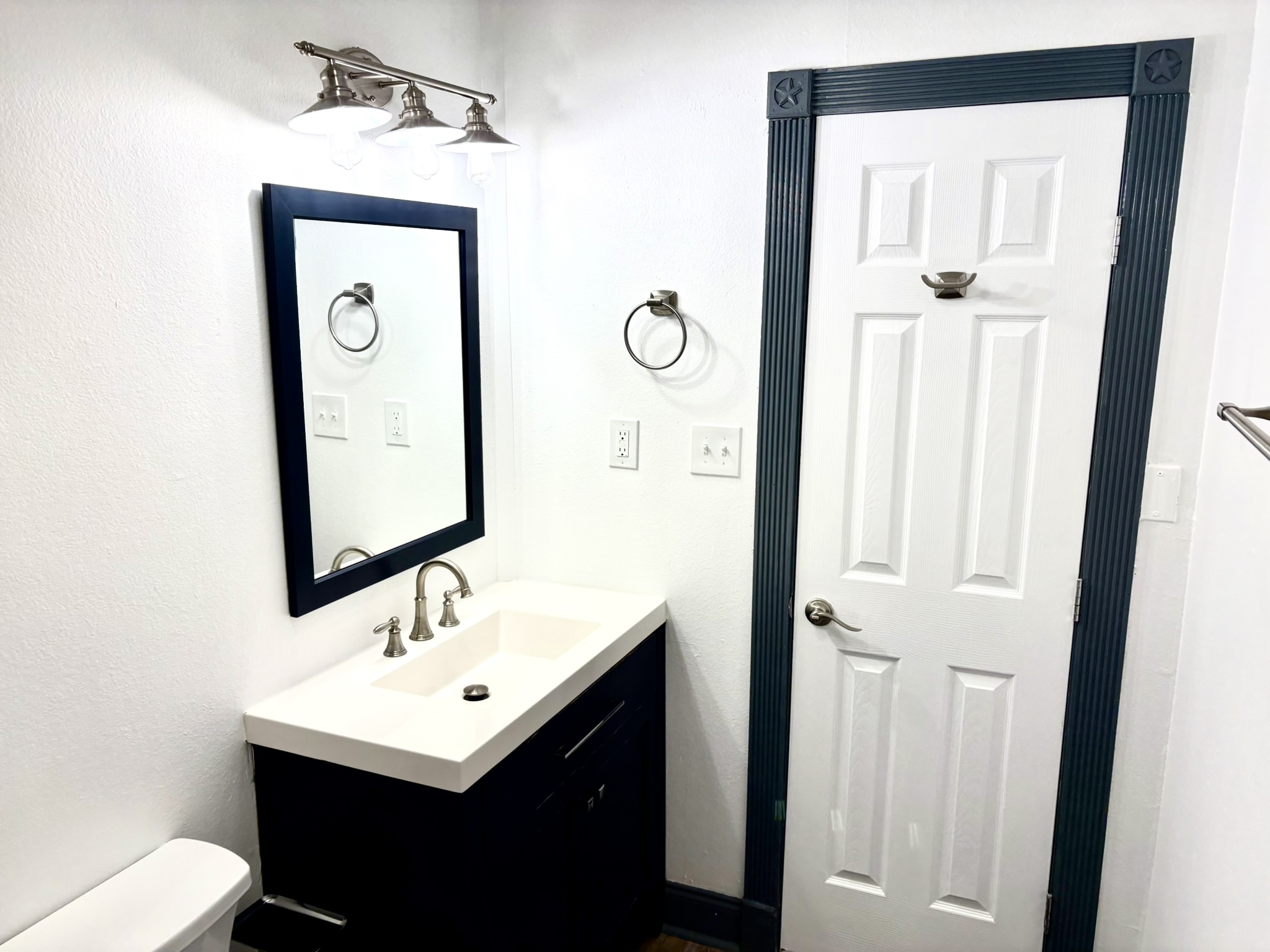 Undisclosed Address Austin, TX 78721 - Photo 11 of 28 Dark trim accents the doorway and vanity cabinet in this updated bathroom.
