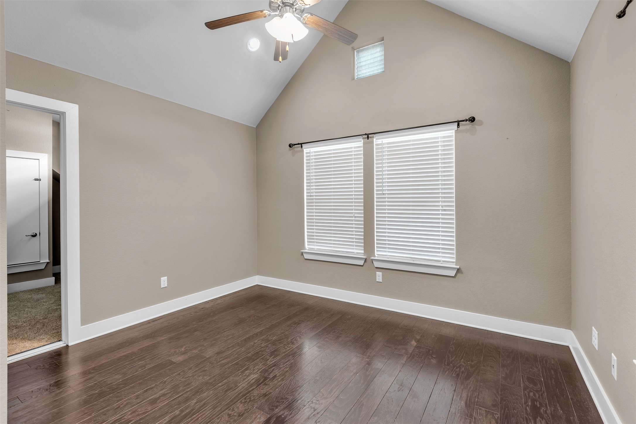 12212 Tawny Farms Road, Unit 142 Austin, TX 78748 - Photo 7 of 21 Hardwood floors and a vaulted ceiling elevate this comfortable primary bedroom.