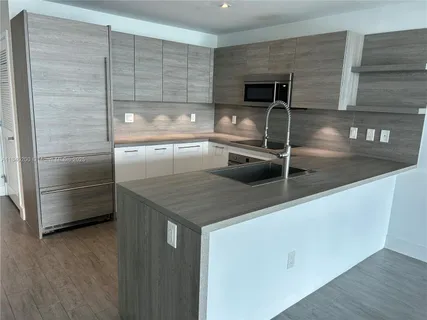 a view closed kitchen with a sink and refrigerator