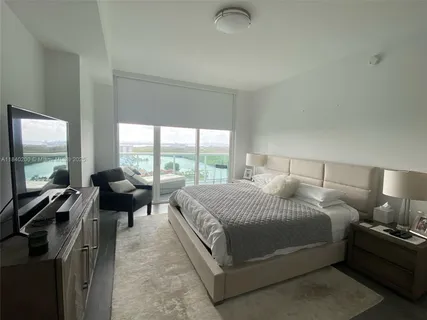 a large bedroom with a bed and large windows