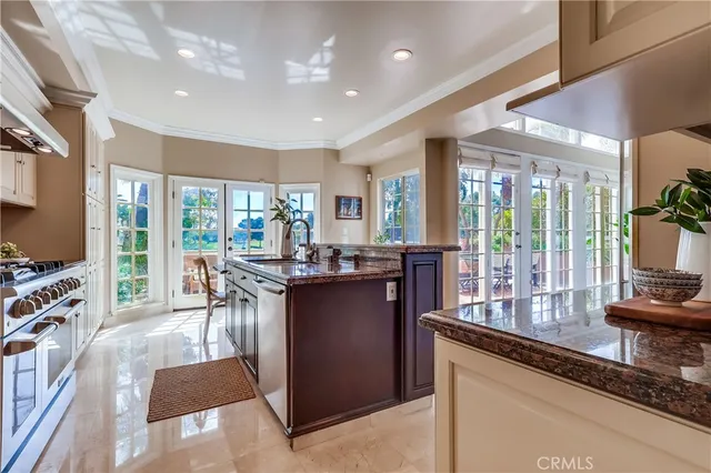 a dining hall with stainless steel appliances granite countertop a couch and a dining table next to a window