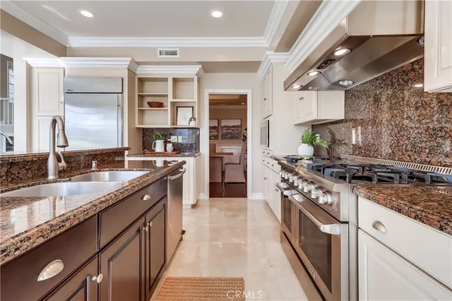 a kitchen with stainless steel appliances granite countertop a stove and a sink