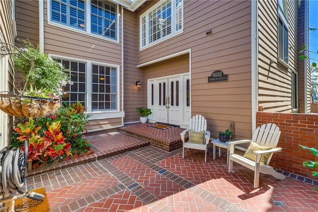 a view of a patio with couches table and chairs and potted plants