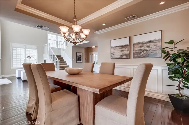 a view of a dining room and livingroom with furniture wooden floor and a chandelier