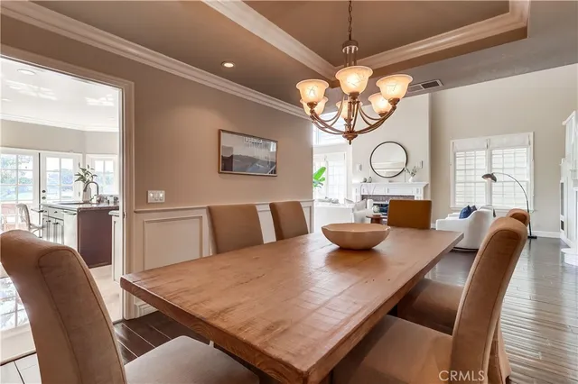 a view of a dining room with furniture a chandelier and large window