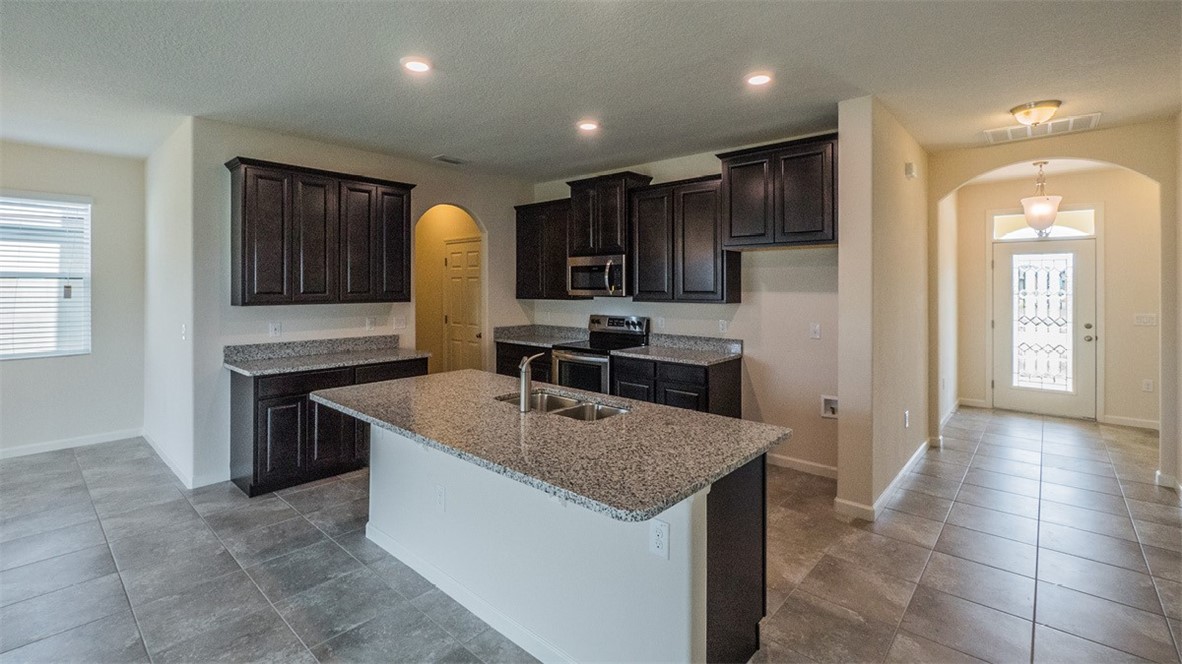 75 52nd Square Vero Beach, FL 32968 - Photo 7 of 29 a kitchen with kitchen island granite countertop a sink a counter top space appliances and cabinets