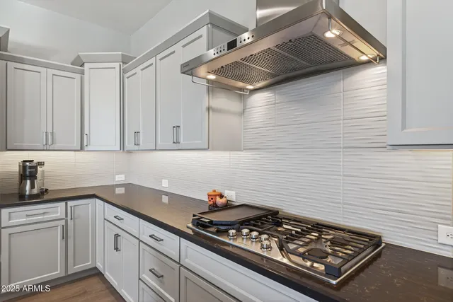 a bathroom with a granite countertop toilet a sink a mirror a window and a shower