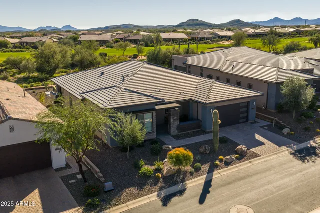 an aerial view of a house with swimming pool and mountains