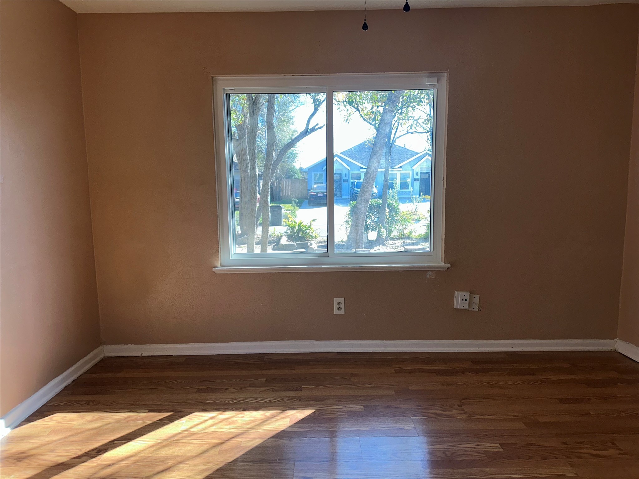 5715 Beldart Street Houston, TX 77033 - Photo 9 of 12 a view of empty room with wooden floor and fan