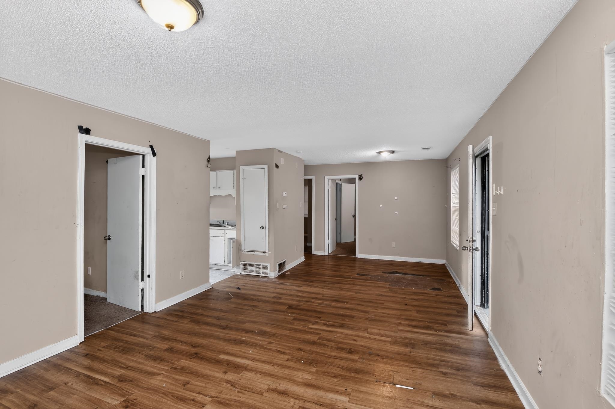 3953 McCain Road Memphis, TN 38109 - Photo 6 of 15 Open concept room featuring wood-finish flooring, neutral-toned walls, and white baseboards