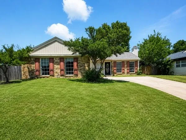 a front view of a house with yard and green space