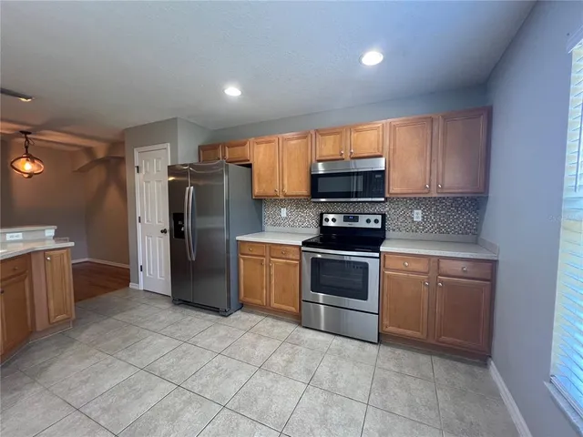 a kitchen with a refrigerator and a stove top oven