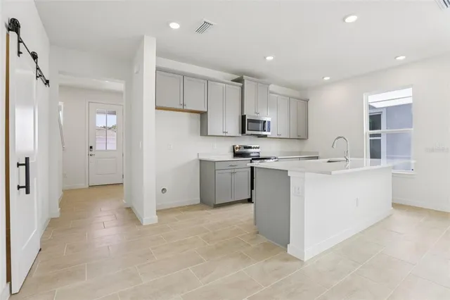a kitchen with kitchen island a sink stainless steel appliances and cabinets